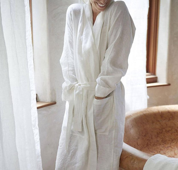 A woman happily wearing a comfortable St. Barts Linen Robe by Rough Linen