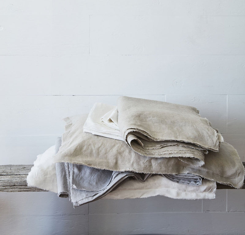 bedroom scene with 100% linen summer cover blanket with frayed raw edge detail natural beige tan color